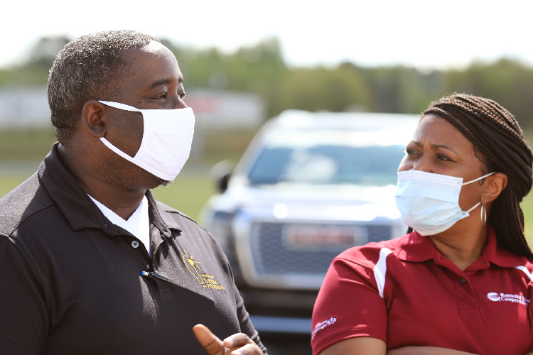 Officials wearing face masks speaking 